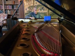 Hugh Gulledge patiently tunes the 1929 Steinway & Sons Model D Concert Grand in the West Wing Library of Cranbrook House. Photographer: Gretchen Sawatzki